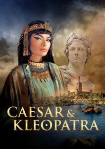 Eine Frau in historischer Kleidung mit ägyptischen Schmuck und Frisur steht im Vordergrund. Im Hintergrund ist eine Statue eines römischen Mannes und eine Landschaft mit antiken Gebäuden und Wasser zu sehen. Der Titel "CAESAR & KLEOPATRA" ist in goldener Schrift am unteren Bildrand platziert.